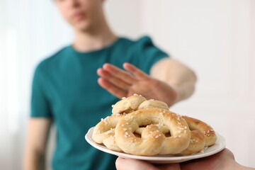 Gluten free diet. Man refusing from pastries indoors, selective focus