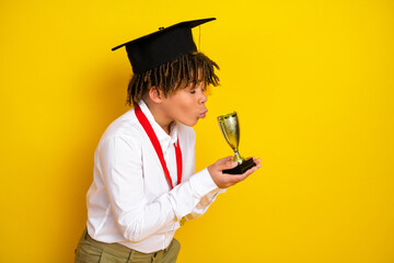 Schoolboy Holding Trophy in Graduation Cap on Yellow Background Celebrating Academic Success and...