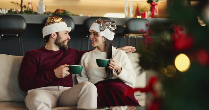 Christmas, coffee and toast with couple on sofa in living room of home together for celebration. Cheers, love and smile with happy people in apartment for festive bonding, holiday or vacation