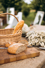 Sourdough bread cut in half and basket with wheat ears, rustic organic bakery.