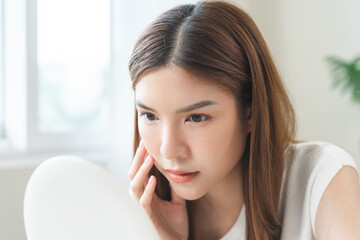 Anti aging, worry puberty asian young woman, stressed girl looking in mirror, allergy presenting an...
