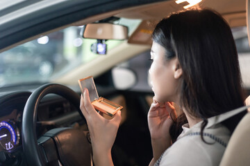 
Young professional women in China are doing their makeup in a small car
