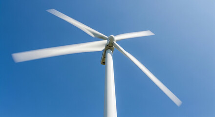 Low angle view of a white wind turbine with four blades against a vibrant blue sky on a sunny day