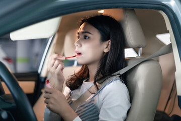 
Young professional women in China are doing their makeup in a small car
