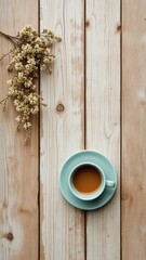 Coffee cup and delicate floral sprig on rustic wooden planks, perfect for a refreshing morning break or a calming afternoon moment