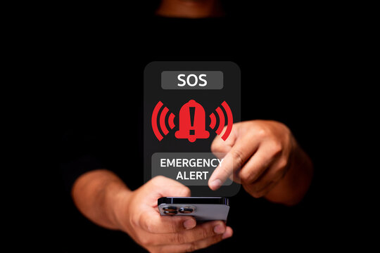 A person activates an emergency alert on a smartphone, displaying an SOS warning with red alert icons on a dark background.