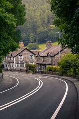 Beautiful British Countryside: Road Curving Past Quaint Houses and Greenery