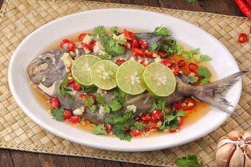 Thai steamed fish served with a bright, punchy  with lots of lime, garlic, chillies, fish sauce and other fragrant aromatics.