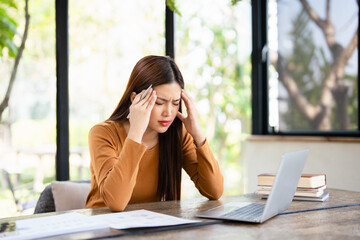  Asian businesswoman are serious at work causing headache stressed out with documents and laptop at the office.