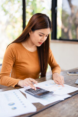 Focused young asian woman work on laptop manage household finances expenditures. Concentrated...