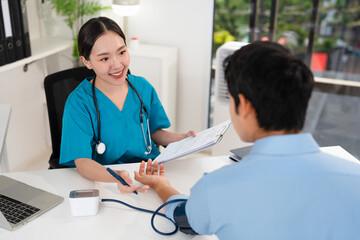 Female doctor giving a consultation to a patient and explaining medical informatics and...