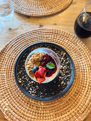 Dessert mit Beeren und Minze auf Holztisch