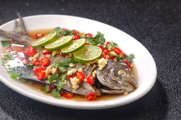 Thai steamed fish served with a bright, punchy  with lots of lime, garlic, chillies, fish sauce and other fragrant aromatics.