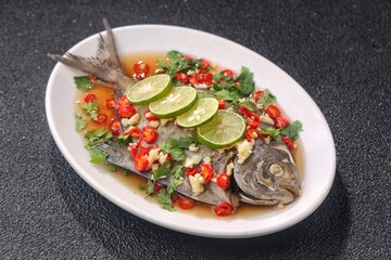 Thai steamed fish served with a bright, punchy  with lots of lime, garlic, chillies, fish sauce and other fragrant aromatics.
