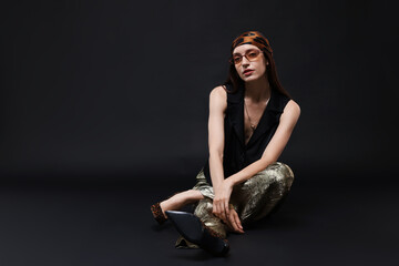 Full-length portrait of beautiful woman in stylish outfit on black background, space for text