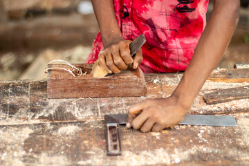 A young man working with a wood cutting machine