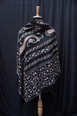 Elegant display of Kashmiri shawls draped on a mannequin, featuring intricate Sozni embroidery that...