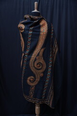 Elegant display of Kashmiri shawls draped on a mannequin, featuring intricate Sozni embroidery that...