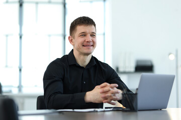 Portrait of handsome man at desk in office