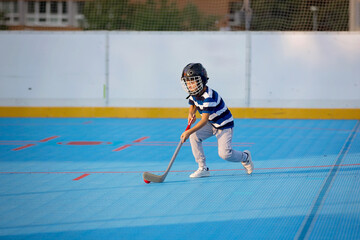 Children playing hockeyball on playground