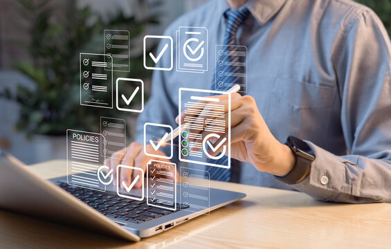 Business performance tracking concept. Businessman using tablet and laptop, completing digital survey form, online checklist, and audit for data analysis and reporting