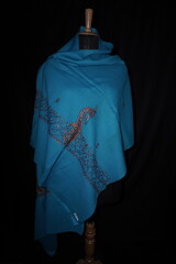 Elegant display of Kashmiri shawls draped on a mannequin, featuring intricate Sozni embroidery that...