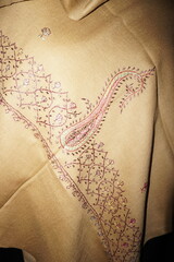 Elegant display of Kashmiri shawls draped on a mannequin, featuring intricate Sozni embroidery that...