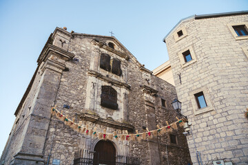 Historic stone church decorated with rustic garlands in Italian village