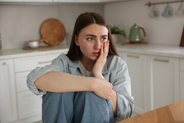 Worried woman suffering from paranoia in kitchen