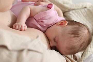 Mother breastfeeding her newborn baby indoors, above view