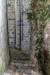A narrow stone stairway tucked between old stone walls in Kotor, Montenegro, leading down a quiet...