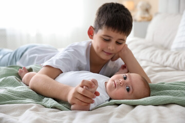 Cute little brothers on bed at home