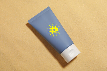 Sunscreen product in tube with drawing of sun on sand, top view