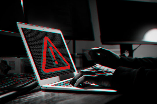 Cyber attack alert notification. Red warning sign and binary code on laptop screen. Hacker using computer, closeup