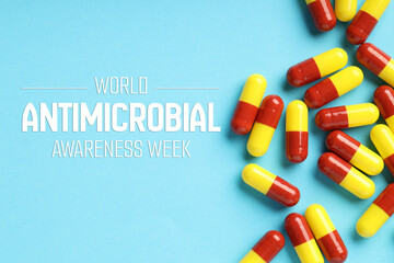 World antibiotic awareness week. Many pills on light blue background, flat lay