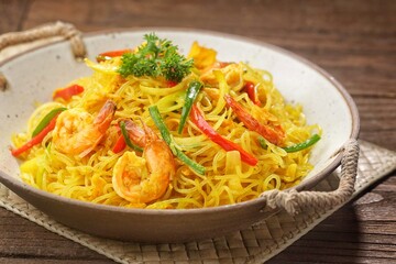 Singapore Mei Fun consists of rice vermicelli seasoned with curry powder, soy sauce and stir-fried with egg, shrimp