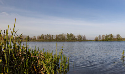 a lake in cloudy weather during the autumn with waves on the water, landscape in nature