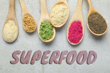 Superfood. Different powders in spoons on grey table, flat lay