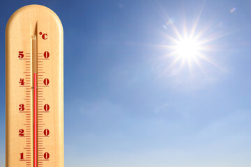 Extremely high temperature on thermometer against blue sky on sunny day. Summer weather