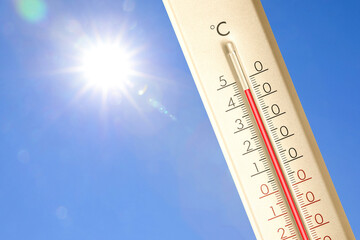 Extremely high temperature on thermometer against blue sky on sunny day. Summer weather