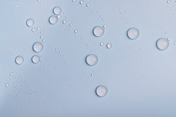 a smooth surface of light blue color covered with water droplets, a beautiful wet blue film in a large number of water drops