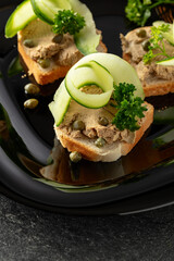 Open sandwiches with pate, fresh cucumber, capers, and parsley.