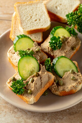 Open sandwiches with pate, cucumber, capers, and parsley.