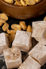 Turkish delight in sugar with nuts , scattered oriental sweets Turkish delight with peanuts on a slate board