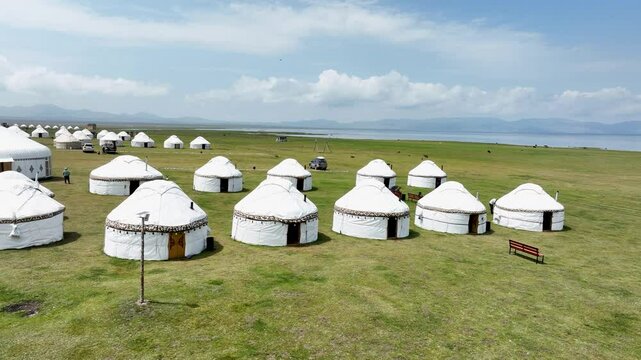 Aerial view of yurts on green field, Kyrgyzstan.