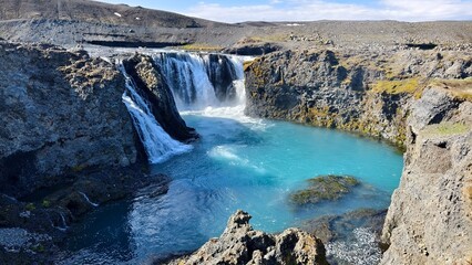 Waterfall on the blue river in Iceland