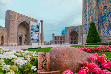 Samarkand, Uzbekistan - May 27, 2025: View of madrasahs at Registan Square and the garden decorated with flowers and clay pot