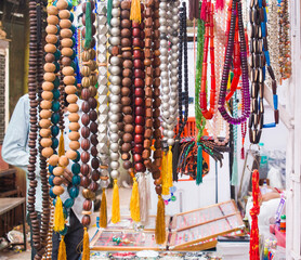 vibrant image of assorted Islamic prayer beads, also known as tasbih or misbaha, hanging on display...