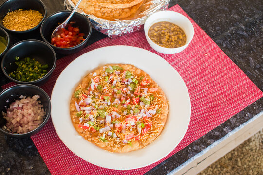 traditional Indian Dal Pakwan dish, a popular breakfast or snack from Sindhi cuisine. The plate features crispy pakwan with spiced chana dal topped with onions, tomatoes, green chutney, and bhujia