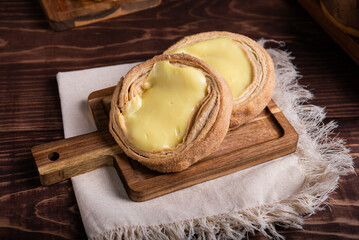 Close-up of two delicious cream-filled pastries, sprinkled with sugar, on a wooden board